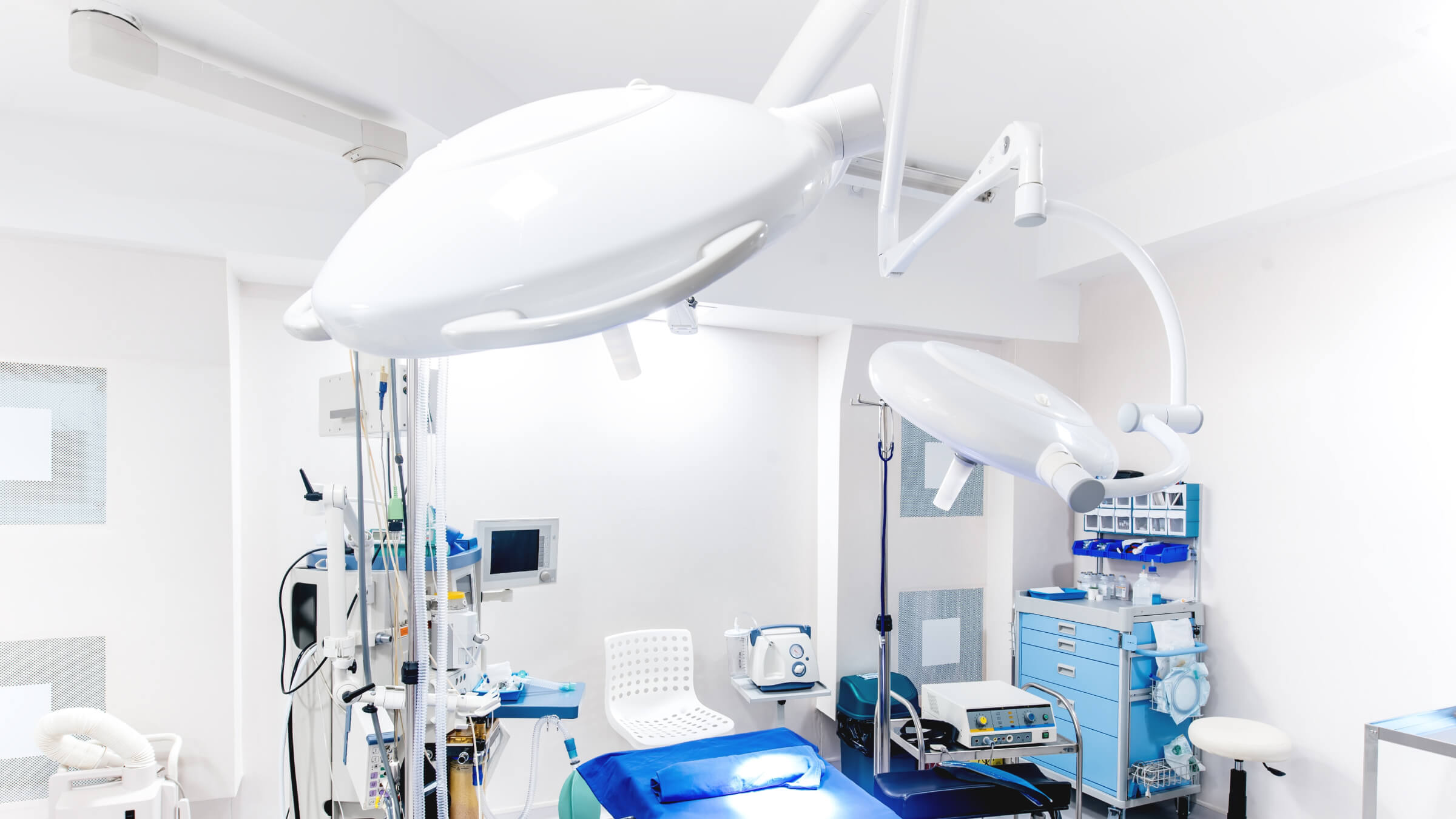 Precision aluminum die cast surgical lighting arm and equipment mounts installed in a modern sterile operating room environment.