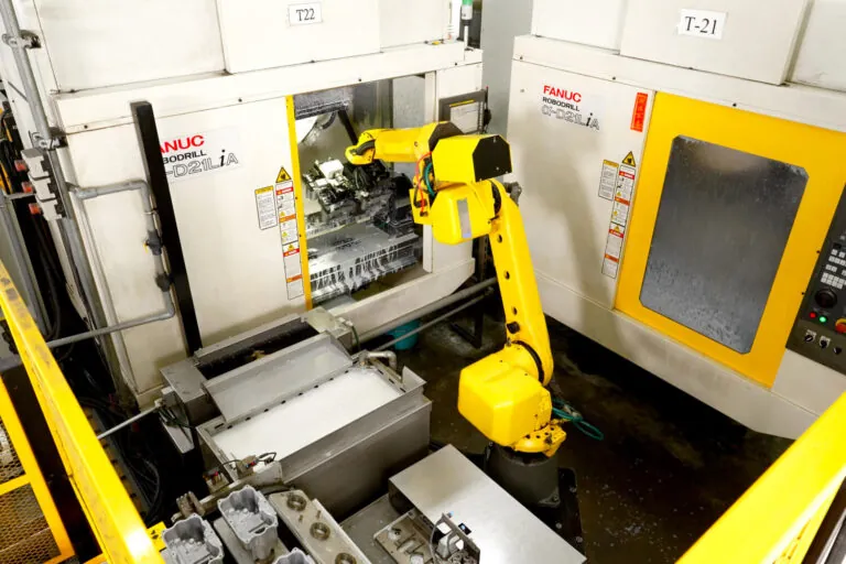 Fanuc robotic arms integrated into the automated aluminum die casting production line for precise material handling and positioning.