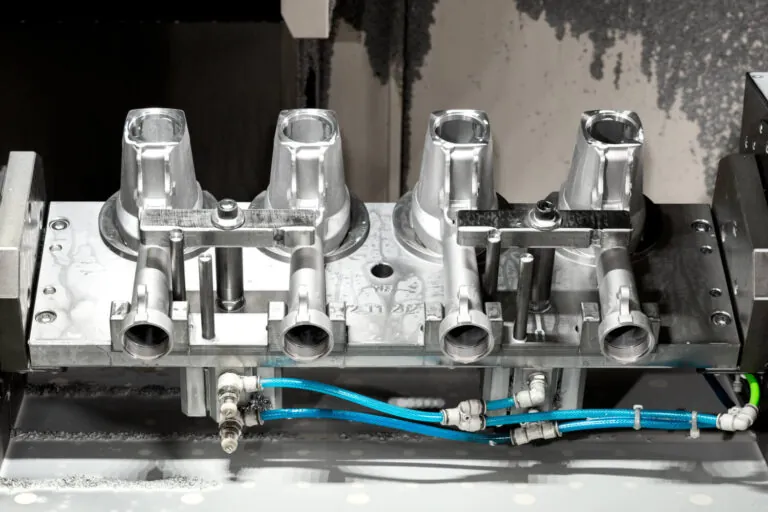 Multi-fixturing setup on a CNC machine for simultaneous precision drilling and milling of aluminum agricultural machinery parts.