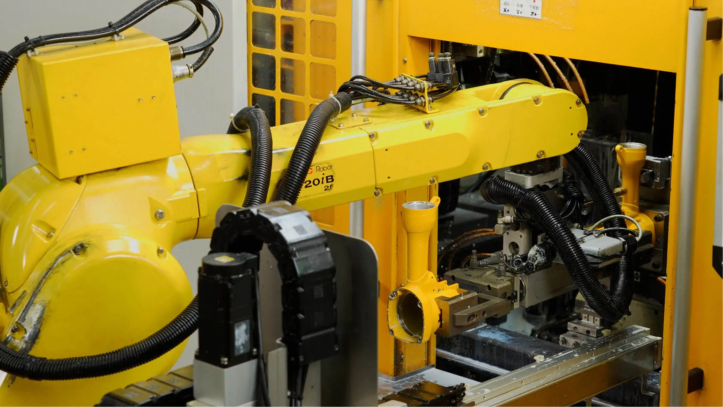 Robotic automated loading system processing yellow powder-coated aluminum components to ensure continuous production with reduced manual handling.