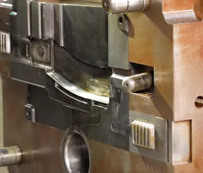 Expert JoinCast technician performing precision maintenance and manual adjustment on a high-pressure aluminum die casting mold.