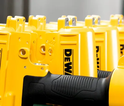 Ergonomic black TPR insert molding bonded to yellow aluminum die-cast pneumatic tool housings, providing superior vibration absorption and grip.