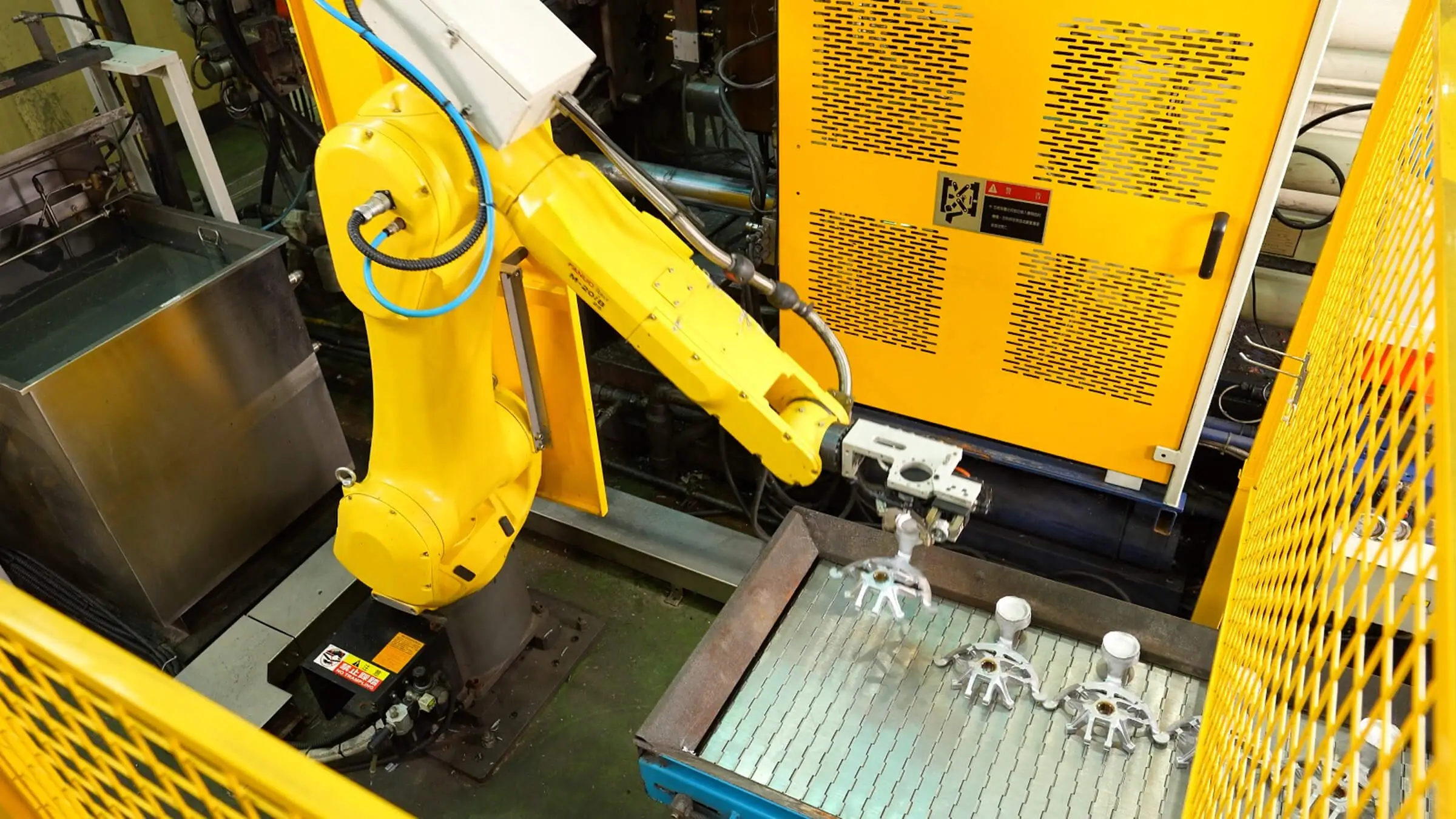 High-pressure aluminum die casting station featuring a Fanuc robotic arm for automated extraction and consistent cycle timing.