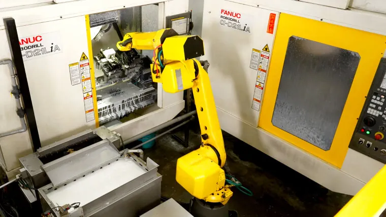 FANUC robotic arm integrated with vertical machining centers for automated material handling and high-volume component manufacturing.
