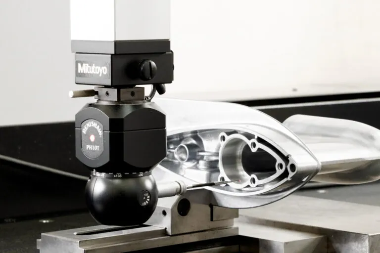 Mitutoyo CMM sampling and Renishaw PH10T probe performing automated dimensional verification on a precision aluminum die cast marine component.