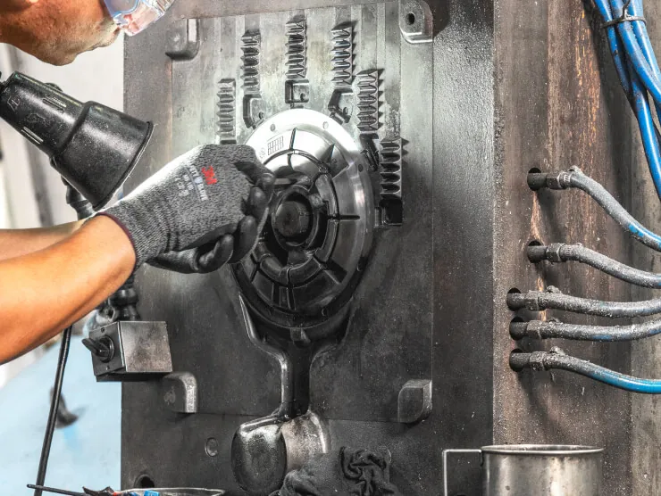 Expert JoinCast technician performing precision maintenance and manual adjustment on a high-pressure aluminum die casting mold.
