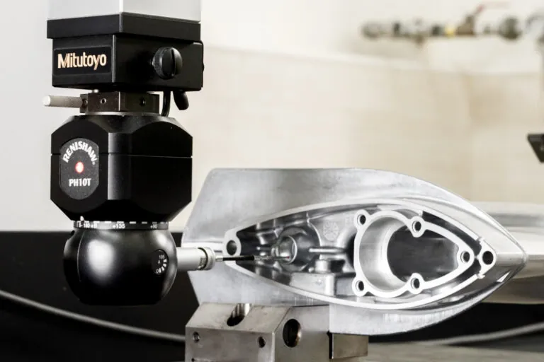 Mitutoyo CMM sampling and Renishaw PH10T probe performing automated dimensional verification on a precision aluminum die cast marine component.