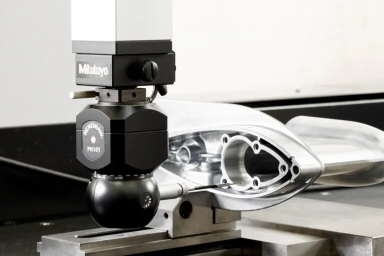 Mitutoyo CMM sampling and Renishaw PH10T probe performing automated dimensional verification on a precision aluminum die cast marine component.