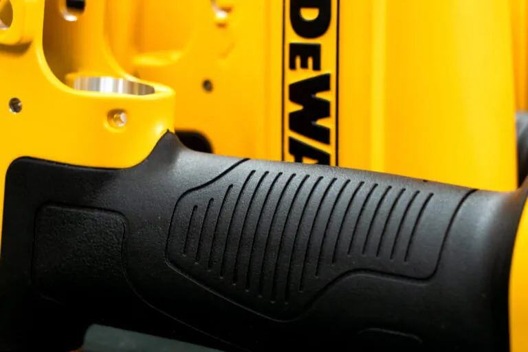 Ergonomic black TPR insert molding on a yellow aluminum die cast pneumatic tool housing, providing superior grip and vibration absorption.