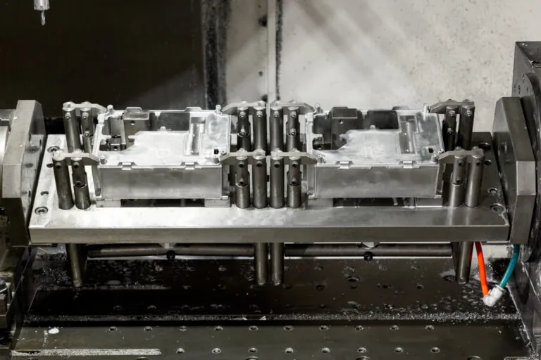 Specialized CNC machining jig securing aluminum electronic enclosures for high-accuracy milling operations.