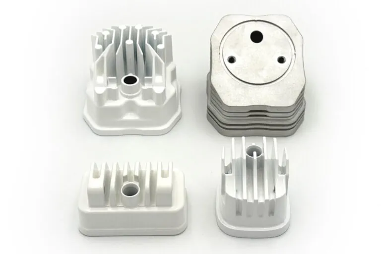 Precision aluminum die-cast components with a white powder-coated finish organized for high-volume quality inspection.